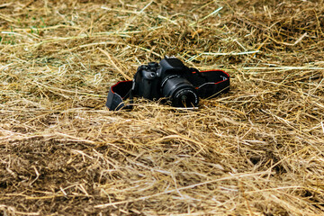 Black camera on natural dry hay