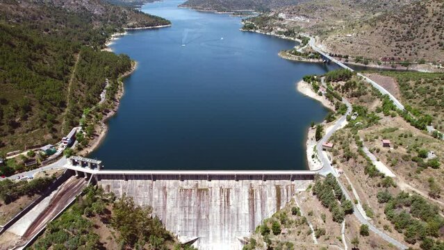 Dam of El Burguillo Reservoir is located along Alberche river in province of Avila, drone point of view during sunny summer day. Spain