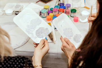 Girls painting with watercolor paints on the table close-up