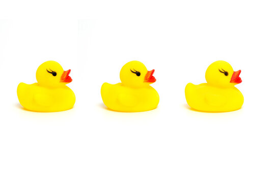 Three yellow ducklings. Baby bath toy isolated on white background.