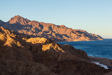 Aerial view of Sinai mountains and Red Sea at sunset. Dahab town, Sinai peninsula, Egypt