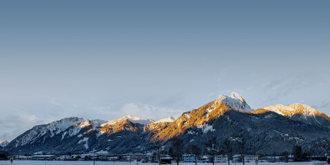 hahnenkamm mountain range in reutte with morning sun-illuminated, snow-capped peaks in winter