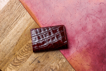 Red passport cover made of genuine leather on a wooden background
