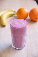 Natural looking purple fruit smoothie juice on a table at home