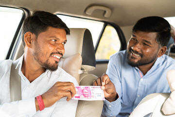 Focus on cab driver passenger or businessman paying money to cab driver for trip - concept of destination, successful journey and self employment