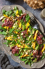 Salad with mango, avocado, arugula and jamon