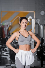 Fototapeta na wymiar Smiling middle east sportswoman looking at camera in gym.
