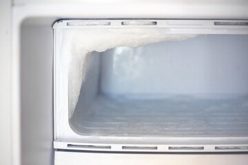 Fridge freezer with frozen ice. Maintenance and defrosting of the refrigerator