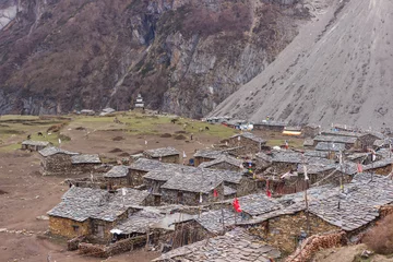 Papier Peint photo Manaslu Stone houses of the village in the Manaslu region against the backdrop of snow-capped mountains
