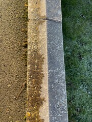 A close up view of the two sides of a wall where the sun has melted the frost and the other side that is still in the shade