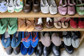 Old children's women's and men's shoes from the times of the USSR are on a shelf. Retro things from the past. Selective focus