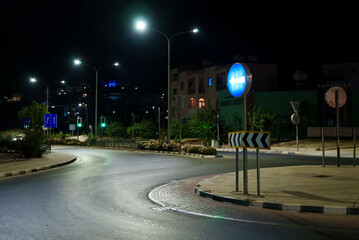 Modern roundabout intersection at night. - obrazy, fototapety, plakaty