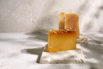 Natural Handmade soap bars on travertine stone podium. Zero waste concept