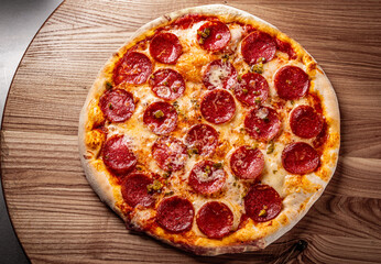 Hot Pepperoni Pizza with Mozzarella cheese, salami, Tomato sauce, pepper, Spices. Italian pizza on wooden background