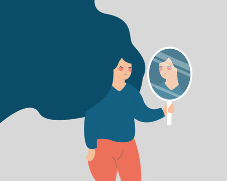 Young woman looks on her reflection in the mirror in a sad way. Girl holding a mirror and looks upset. Mental health illness, depression, stress, lack of confidence, Body Dysmorphic Disorder concept.