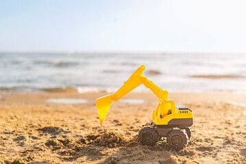Fototapeta na wymiar Toy excavator on the beach with copy space