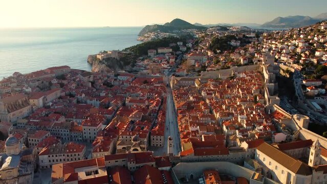 Amazing panoramic sunset drone view of old city of Dubrovnik, Croatia. View of the historical center and main street named Stradun in the sunset rays.