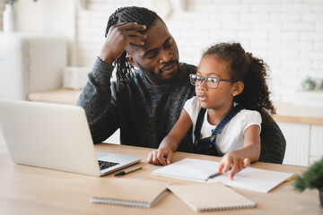 School problems. Homeschooling. African-american father dad helping assisting daughter with homework, school load. Tutor explaining hard difficult task to a student with laptop. Distant e-learning