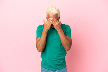 Young Colombian handsome man isolated on pink background with tired and sick expression