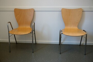 Wartezimmer in Arztpraxis mit zwei Holzstühlen 