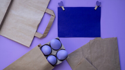 Easter eggs on a lilac background. Easter. Reusable paper eco bag. Holiday postcard.