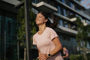 Fit athlete woman in sportswear outdoors. Young woman jogging outside.