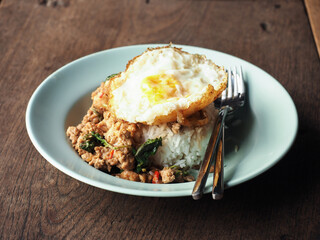 Thai stir-fried meat with holy basil leaves served with sunny side up egg and rice