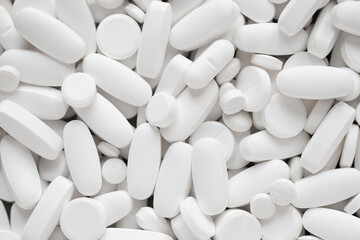 Assorted white tablets, pills, drugs background. Medication and healthcare concept. Close up, top view