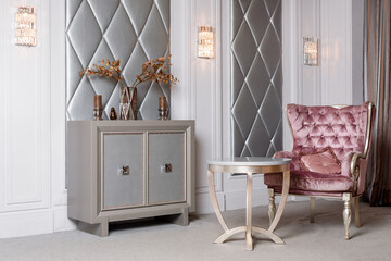 Luxury Interior. Luxurious pink velvet armchair, antique carved furniture, classic interior.