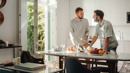 Stylish Young Adult Gay Couple at Home in Casual Clothes in Kitchen Area. Handsome Male Cutting Apples and Preparing Lunch. Partners Talking and have Fun. Cute LGBTQ Relationship Content.