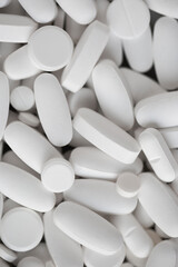 Assorted white tablets, pills, drugs background. Medication and healthcare concept. Close up, top view