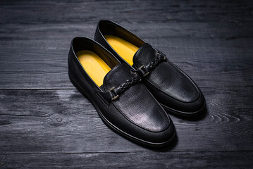 men's black leather shoes on a black wooden background