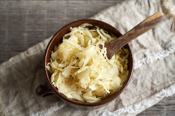 Fermented cabbage or sauerkraut in a pot with a spoon - obrazy, fototapety, plakaty