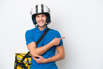 Young caucasian man with thermal backpack isolated on white background pointing finger to the side