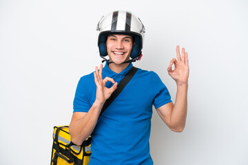 Young caucasian man with thermal backpack isolated on white background showing an ok sign with fingers