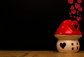 Mushroom-shaped house with hearts on a black background. Love valentine concept