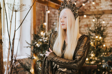 young albino woman with blue eyes and long white hair in beautiful green dress and crown stands in loft room decorated with wooden greenhouse and Christmas trees with twinkle lights, diverse people - obrazy, fototapety, plakaty