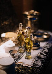 Essential oils with various herbs and flowers near candles