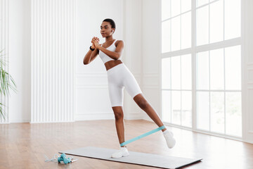 Focused African Woman In Sportswear Exercising With Elastic Band