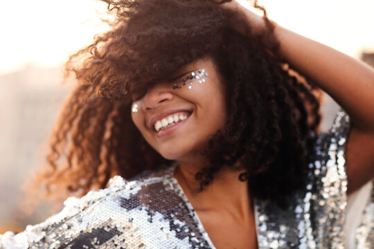 Outdoor portrait of happy glamour african american party girl with glitter on face