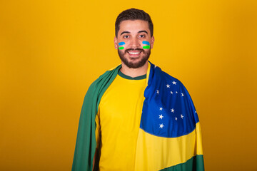 Brazilian man, latin american, cheering for brazil, in the world cup 2022, looking at camera,...