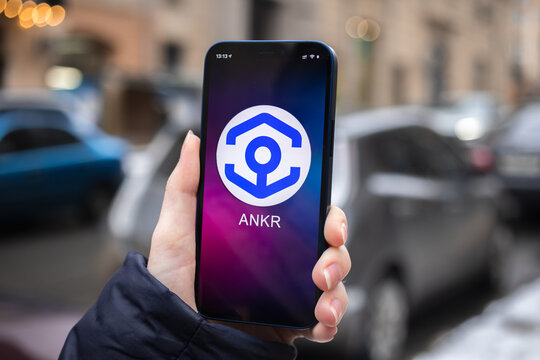 ANKR coin symbol. Trade with cryptocurrency, digital and virtual money, mobile banking. Hand with smartphone, screen with crypto icon close-up. Business and financial concept photo
