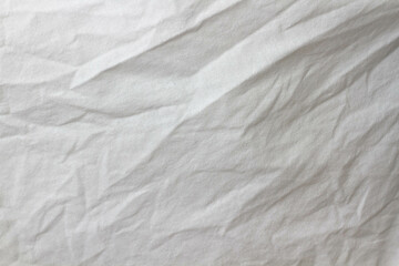 Wrinkled sheet. White fabric close-up. Burlap texture. Sheet on the bed.