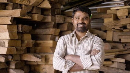 Confident smiling carpenter with arms crossed standing by looking at camera - concept of self confidence, skilled professional occupation and successful worker