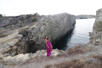 Fototapeta premium woman in a pink dress on a beach in milos greece