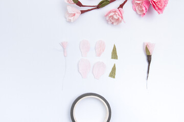 Create a sakura flower from 4 light pink crepe paper petals. Cut out the petals and fasten with a thread on a wire with a stamen