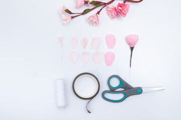 Creation of a sakura flower from 8 petals of corrugated paper in two shades of pink. Cut out the petals and fasten with a thread on a wire with a stamen