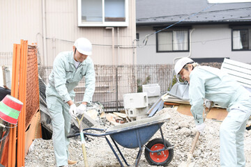 工事現場で作業をする作業服姿の男性達