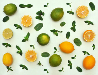Set of fresh lemons and limes full and slices with mint leaves isolated on a  light green background. Healthy food photo .Top view
