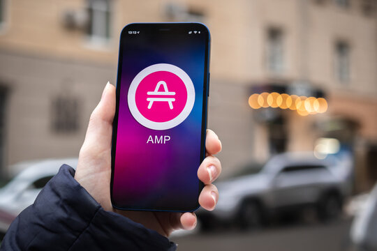 AMP symbol. Trade with cryptocurrency, digital and virtual money, mobile banking. Hand with smartphone, screen with crypto icon close-up. Business and financial concept photo